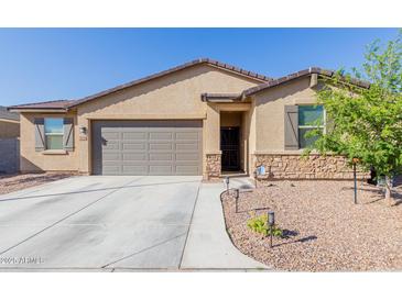 Charming single-story home with a stone facade, landscaped front yard, and two-car garage at 10138 W Wood St, Tolleson, AZ 85353