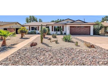 Charming single-story home with desert landscaping, rocks and cacti at 1643 W Harmont Dr, Phoenix, AZ 85021