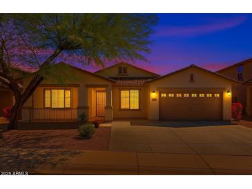 Charming single-Gathering home showcasing a well-maintained front yard and inviting curb appeal at twilight at 18325 W Port Au Prince Ln, Surprise, AZ 85388
