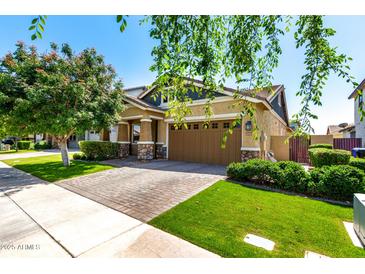 Beautiful single-Gathering home featuring a well-manicured lawn, brick driveway, and an attached two-car garage at 3023 E Arabian Dr, Gilbert, AZ 85296