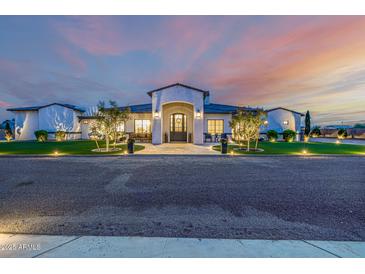 Beautiful custom home with professionally landscaped yard and decorative front entry at dusk at 447 W Judd Rd, San Tan Valley, AZ 85143