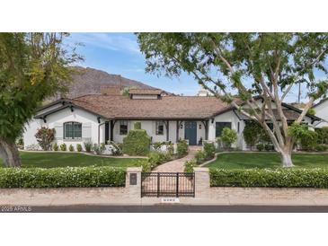 Charming single-story home with a tile roof, brick pathway and lush, meticulously maintained landscaping at 6102 E Calle Del Norte --, Scottsdale, AZ 85251