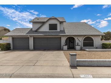 Charming home featuring a three-car garage, arched entry, and well-maintained landscaping at 6237 W Altadena Ave, Glendale, AZ 85304