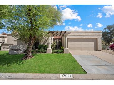 Inviting single-story home featuring a well-manicured lawn and charming desert landscaping at 6252 E Aire Libre Ln, Scottsdale, AZ 85254