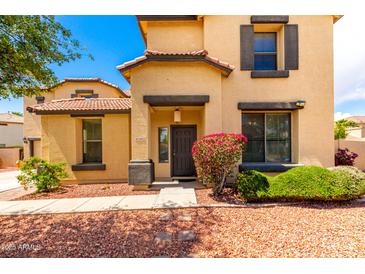 Inviting two-story home featuring a well-maintained front yard with mature landscaping at 13932 N 135Th Dr, Surprise, AZ 85379