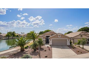 Inviting single-story home with a well-manicured front yard and beautiful lake view at 1806 N 108Th Ave, Avondale, AZ 85392