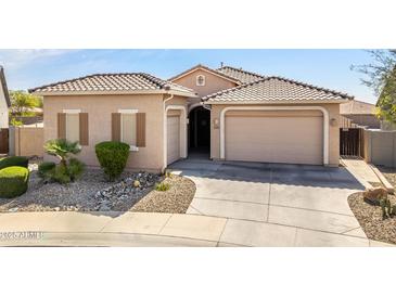 Charming single-story home featuring a tile roof, multiple garage spaces and desert landscaping at 24127 N 166Th Ct, Surprise, AZ 85387