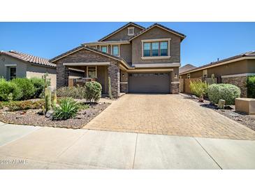 Beautiful two-story home showcasing a well-manicured front yard and brick driveway at 33275 N 132Nd Ave, Peoria, AZ 85383