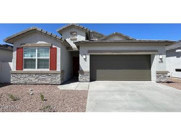 Charming single-story home featuring stone accents, desert landscaping and a two car garage at 4922 S 105Th Ln, Tolleson, AZ 85353