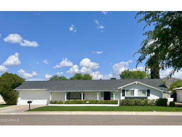 Charming single-story home with a well-manicured lawn and a classic white exterior at 512 W Seldon Ln, Phoenix, AZ 85021