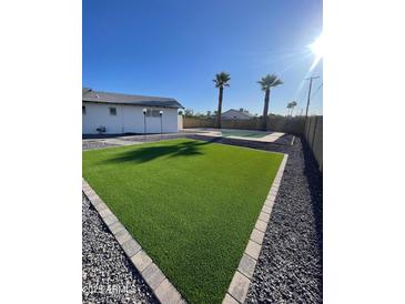 The artificial turf is surrounded by pea gravel and a view of the pool at 7637 E Akron St, Mesa, AZ 85207