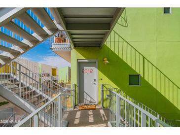 Modern building with vibrant green exterior walls and open stairway access to residences at 1111 W University Dr # 2012, Tempe, AZ 85281
