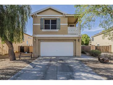 Two-story home with a balcony, a two-car garage, and desert landscaping at 14874 W Laurel Ln, Surprise, AZ 85379