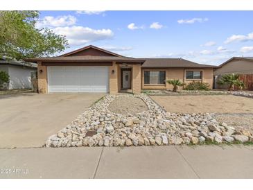 Charming single story home with a two-car garage and low maintenance desert landscaping at 15619 N 58Th Ave, Glendale, AZ 85306