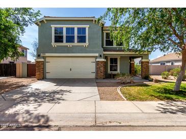 Inviting two-story home featuring stone accents, a two-car garage, and a well-maintained front yard at 1761 E 38Th Ave, Apache Junction, AZ 85119