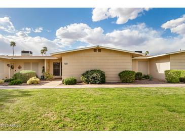 Inviting single-story home with manicured lawn and desert landscaping under a beautiful blue sky at 17627 N 104Th Ave, Sun City, AZ 85373
