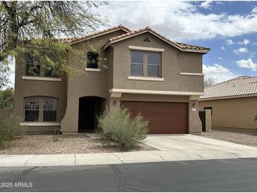 Two-story home with neutral paint, red tile roof, and two-car garage at 1876 N Parkside Ln, Casa Grande, AZ 85122