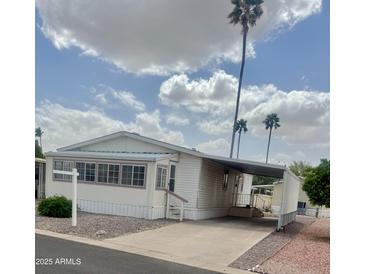 Well-maintained single-story home featuring a covered carport and low maintenance landscaping with desert surroundings at 201 S Greenfield Rd # 76, Mesa, AZ 85206