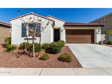 Charming home featuring a low-maintenance landscaped front yard and attached two-car garage at 21056 W Granada Rd, Buckeye, AZ 85396