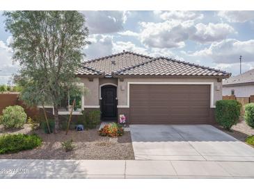 Charming single-story home with a well-maintained front yard and two-car garage at 21882 N 260Th Ln, Buckeye, AZ 85396