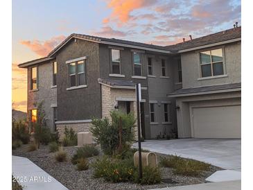 Charming two-story home boasts manicured landscaping and a warm, inviting facade at sunset at 5100 E Rancho Paloma Dr # 1044, Cave Creek, AZ 85331