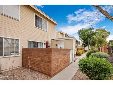 Charming townhome exterior with a brick patio, beige siding, and a well-maintained landscape at 625 S Westwood -- # 121, Mesa, AZ 85210