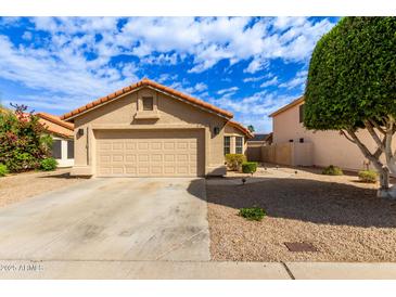 Charming single-story home featuring a two-car garage and desert landscaping at 7822 W Mcrae Way, Glendale, AZ 85308