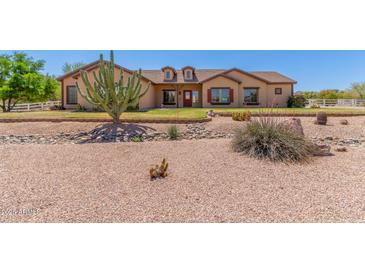 Charming single-story home featuring desert landscaping, a red front door, and dormer windows at 9625 W Prospector Dr, Queen Creek, AZ 85144