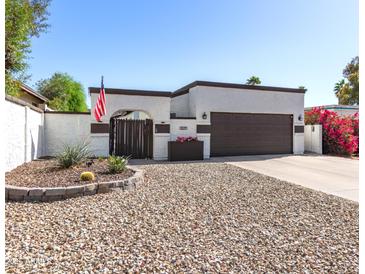 Inviting single-story home with gated front entry, desert landscaping, and a two-car garage at 1029 E Marco Polo Rd, Phoenix, AZ 85024