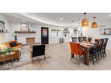 Open-concept living room and dining area boasts a cozy fireplace and stylish furnishings at 1307 E Encanto St, Mesa, AZ 85203