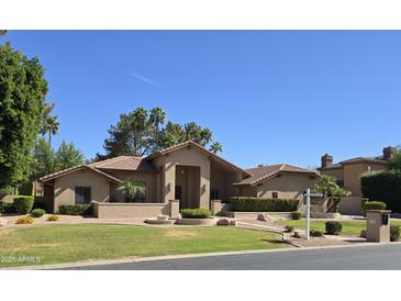 Beautiful single-story home with a well-manicured lawn and desert landscaping at 1348 E Los Arboles Dr, Tempe, AZ 85284
