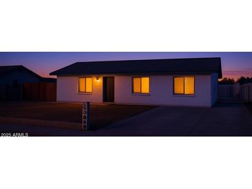 Charming single-story home with a well-manicured lawn and inviting curb appeal during twilight at 18828 N 17Th Dr, Phoenix, AZ 85027