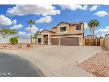 Inviting two-story home with a three-car garage, desert landscaping, and stone accents at 2143 N Chestnut Cir, Mesa, AZ 85213