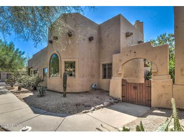 Stunning exterior with private wooden gated entrance, desert landscaping, and a beautiful adobe facade at 38065 N Cave Creek Rd # 9, Cave Creek, AZ 85331