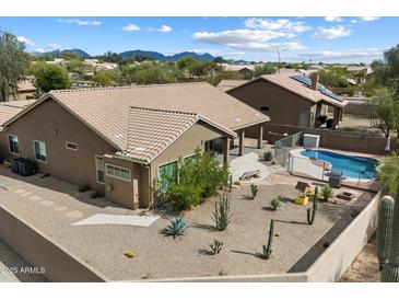 Backyard oasis features a pool, covered patio, and desert landscaping, perfect for outdoor living and entertaining at 5005 E Baker Dr, Cave Creek, AZ 85331
