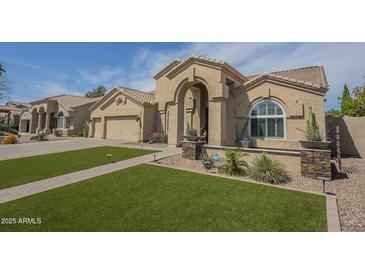Charming single-story home featuring a well-manicured lawn and a welcoming arched entryway at 5900 W Orchid Ln, Chandler, AZ 85226