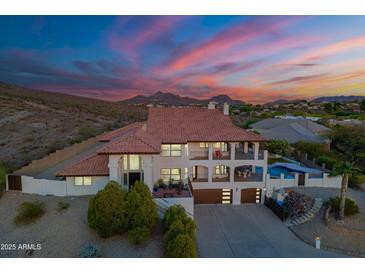 Stunning exterior view of home with multi-level balconies, sparkling pool, gorgeous mountain views, and desert landscaping at 1234 E Claire Dr, Phoenix, AZ 85022