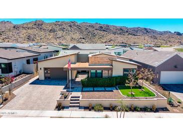 A contemporary single-Gathering home features manicured landscaping and mountain views at 1341 E Paseo Way, Phoenix, AZ 85042