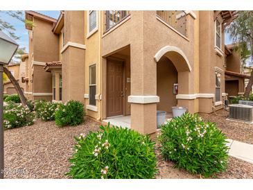 Charming condo exterior featuring a covered entry and well-maintained landscaping at 14250 W Wigwam Blvd # 2111, Litchfield Park, AZ 85340