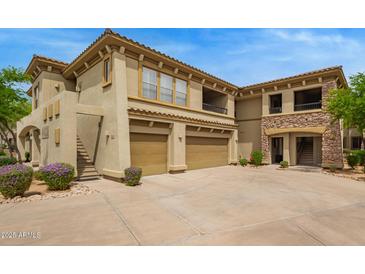 The exterior view of a home with a private two-car garage, balcony, and desert landscaping at 19700 N 76Th St # 2101, Scottsdale, AZ 85255