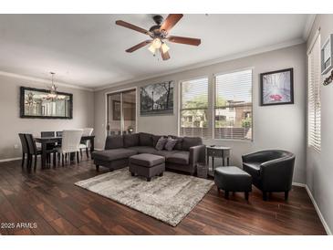Inviting living room featuring a plush gray sectional, ceiling fan, and dark wood floors at 19777 N 76Th St # 1131, Scottsdale, AZ 85255