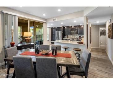 Contemporary dining area with wood table, seating for six, and an open layout flowing into the kitchen at 2425 W Bronco Butte Trl # 1056, Phoenix, AZ 85085