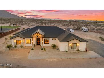 Stunning modern farmhouse with desert landscaping, beautiful sunset and a long driveway at 35280 N Bell Rd, Queen Creek, AZ 85144
