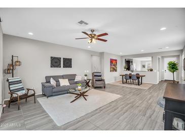 Spacious living room features modern décor, plush seating, and an open floor plan to the dining area at 7070 W Andrea Dr, Peoria, AZ 85383