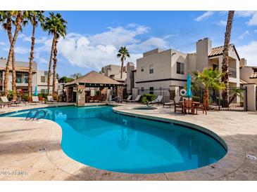 Community pool with sun loungers and covered seating area, perfect for relaxation and entertainment at 14145 N 92Nd St # 1158, Scottsdale, AZ 85260