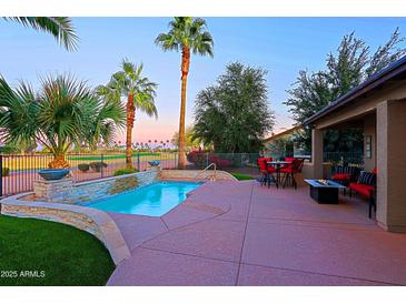 Inviting pool and patio area with golf course views and mature landscaping create a backyard paradise at 15954 W Sheila Ln, Goodyear, AZ 85395