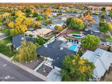 Aerial shot of a property with a sparkling pool and mature trees in a residential neighborhood at 1609 W State Ave, Phoenix, AZ 85021