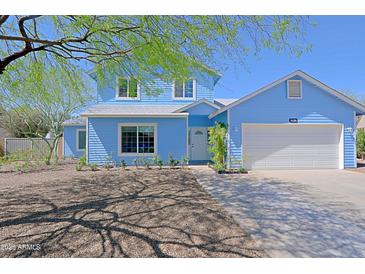 Charming two-story home featuring a well-maintained front yard and a cozy covered entrance, with a large driveway at 16256 N 64Th Pl, Scottsdale, AZ 85254
