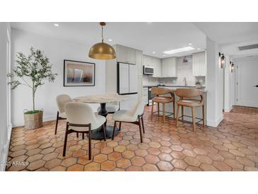 Charming dining area with a marble table, stylish chairs, and unique terracotta tiled flooring at 2814 N 62Nd N St, Scottsdale, AZ 85257