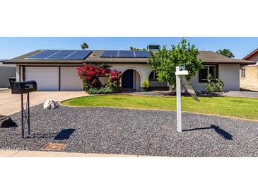 Charming single-story home with solar panels, low-maintenance landscaping, and a welcoming arched entryway at 3516 W Brown St, Phoenix, AZ 85051